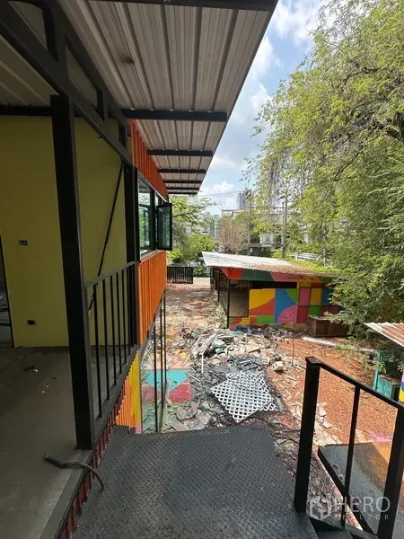 Detached House for rent in Watthana, Bangkok - Second-floor walkway overlooking the courtyard and red-roof pavilion.