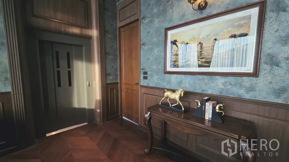 Detached House for rent in Prawet, Bangkok - Penthouse foyer with artwork, wood panels and a lift entrance.