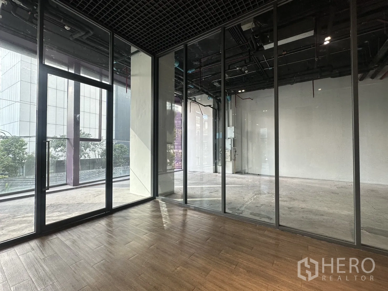 Retail Space for rent in Khlong Toei, Bangkok - Glass-partitioned room with wood-look flooring facing the main retail hall.