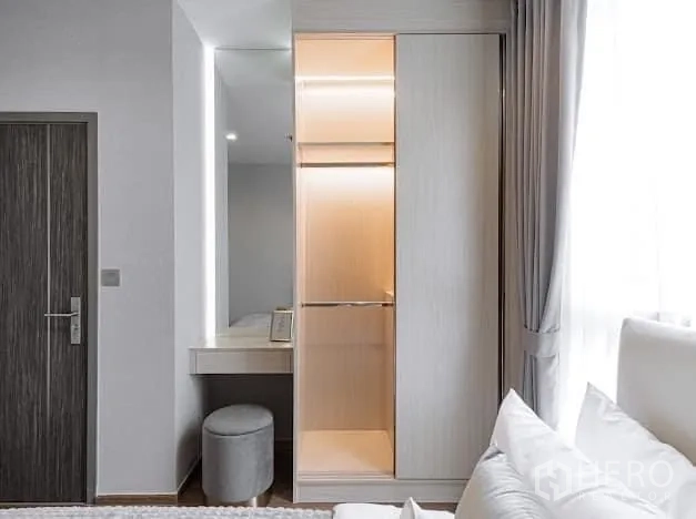 Condominium for rent in Watthana, Bangkok - Built-in closet with warm lighting beside dressing nook and window.