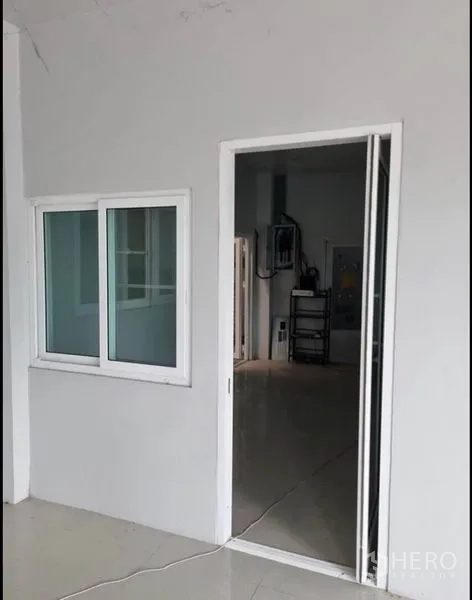 货栈 出租在Khlong Luang, Pathum Thani - 仓库内的办公室入口，白色推拉门与窗户。