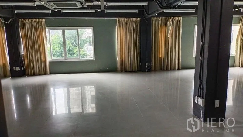 สำนักงาน ให้เช่าในPrawet, Bangkok - ฮอลล์สำนักงานกว้าง มีเสา ผ้าม่านสีครีม และวิวต้นไม้ผ่านหน้าต่างบานกว้าง