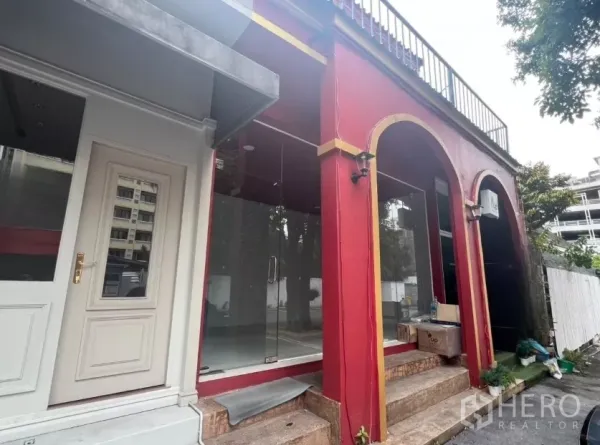 Retail Space for rent in Watthana, Bangkok - Angled exterior of small shop unit showing arched columns and neighboring entrance.