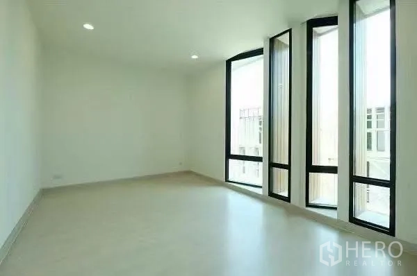 สำนักงานที่บ้าน ให้เช่าในChatuchak, Bangkok - ห้องนอนกว้างพร้อมหน้าต่างบานสูงสามบานและพื้นลายไม้โทนอ่อน