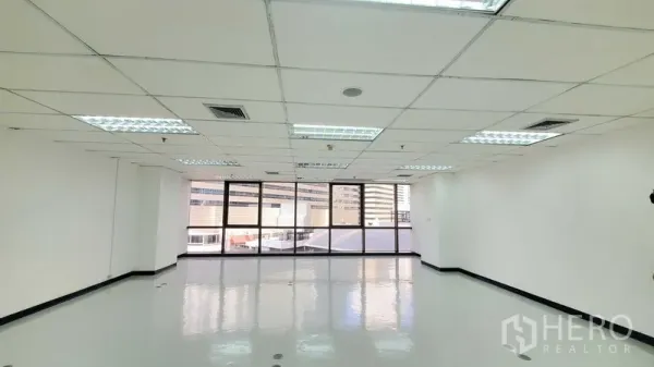 办公空间 出租在Watthana, Bangkok - 明亮的开放式办公区，亮面地坪、格栅天花灯，整面大窗享城市景观。