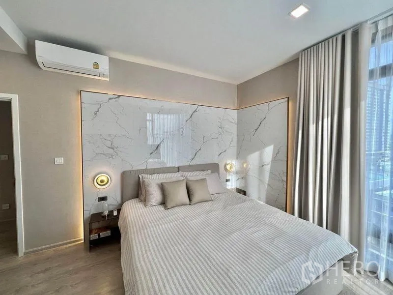 公寓 出租在Watthana, Bangkok - 温馨卧室，石纹墙板、床头灯与大窗帘。