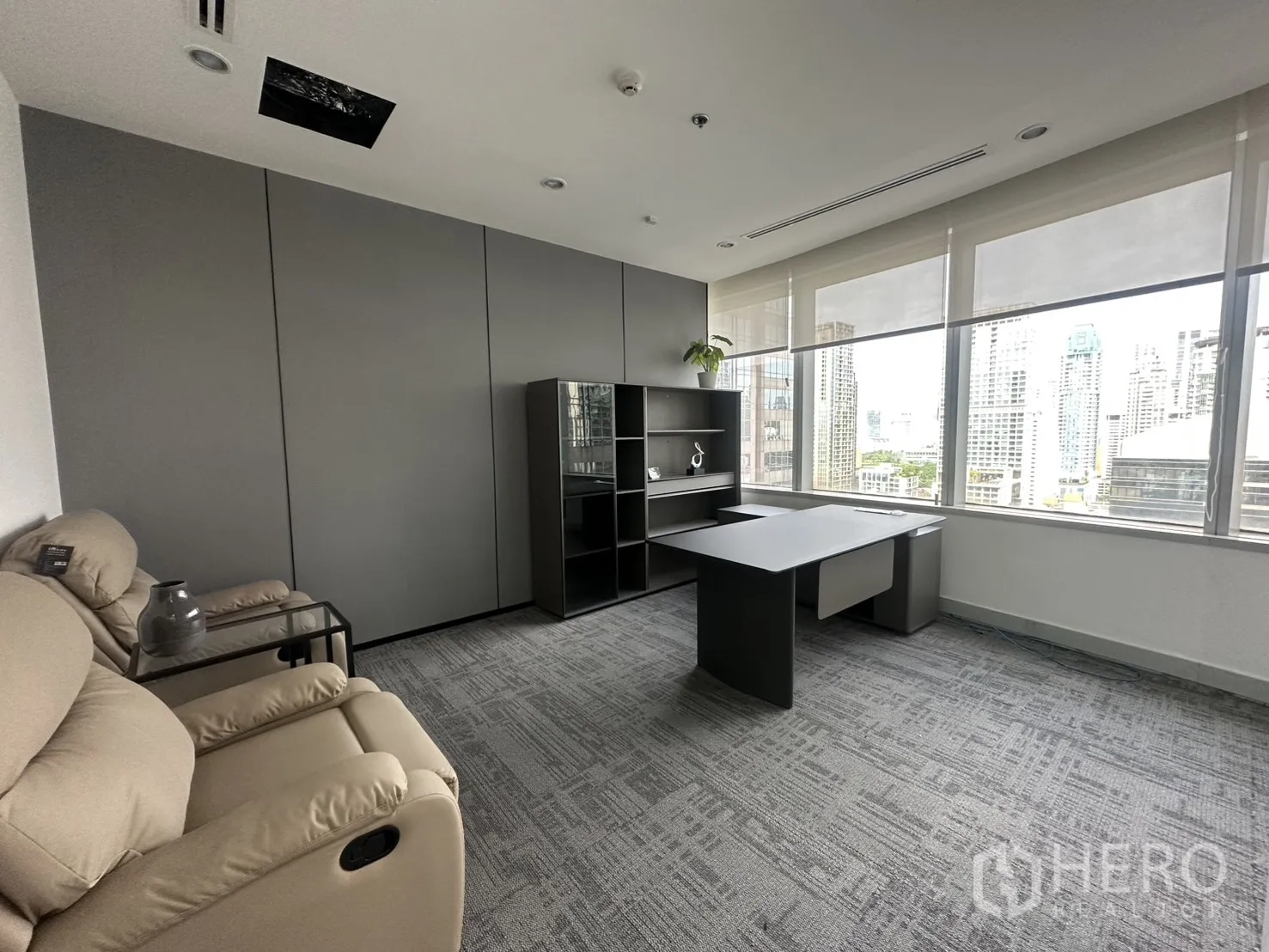 办公室 for rent in Pathum Wan, Bangkok - 经理室配大书桌、置物柜与米色躺椅，采光良好。