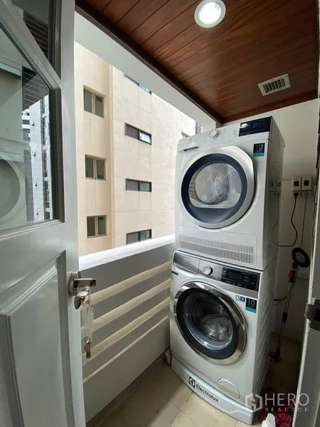 คอนโด ให้เช่าหรือขายในWatthana, Bangkok - ระเบียงซักล้างขนาดกะทัดรัด พร้อมเครื่องซักผ้าและเครื่องอบผ้าแบบตั้งซ้อน มองเห็นวิวเมืองบางส่วน