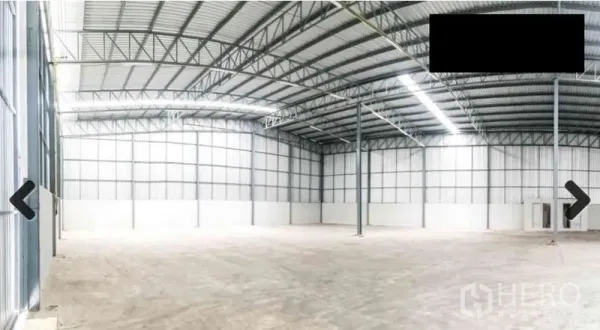 Warehouse for rent in Bang Phli, Samut Prakan - Open warehouse floor with concrete surface, tall columns, and insulated metal wall panels.