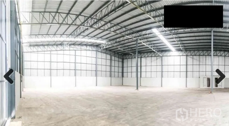 Warehouse for rent in Bang Phli, Samut Prakan - Open warehouse floor with concrete surface, tall columns, and insulated metal wall panels.