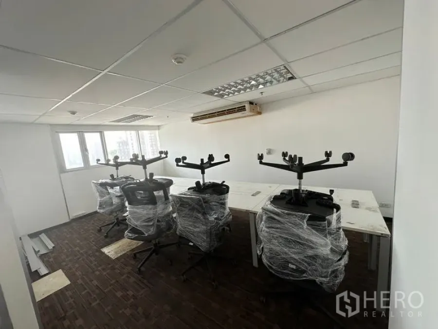 Office Space for rent in Watthana, Bangkok - Open-plan workspace with wrapped task chairs and long desks by the window.