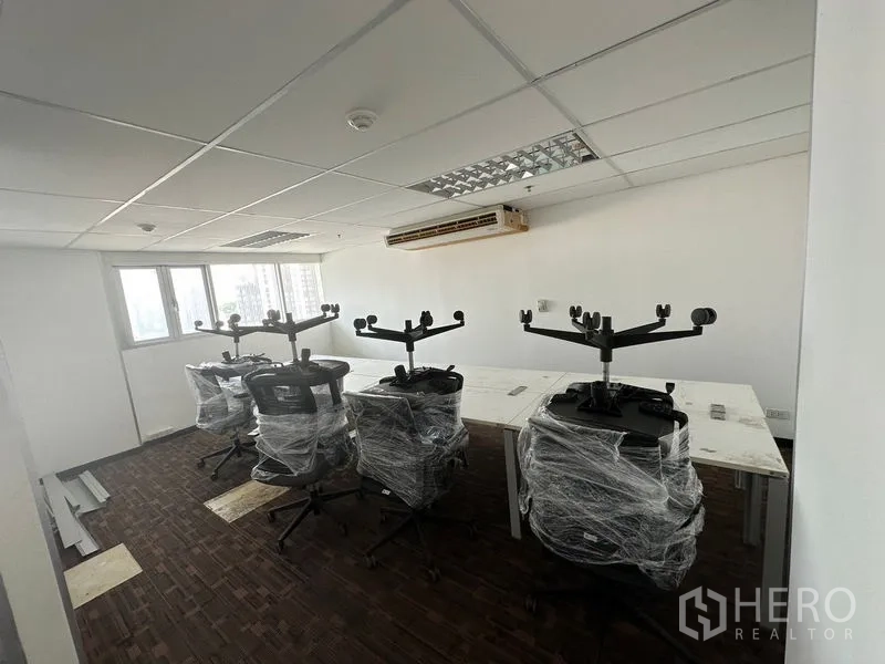 Office Space for rent in Watthana, Bangkok - Open-plan workspace with wrapped task chairs and long desks by the window.