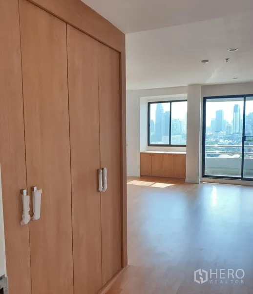 คอนโด ให้เช่าในWatthana, Bangkok - ทางเดินมีตู้เสื้อผ้า เปิดสู่ห้องนั่งเล่นสว่างพร้อมวิวสกายไลน์