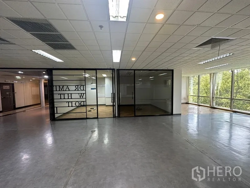 Office Space for rent - Open office area facing glass-partitioned rooms and exterior windows with natural light.