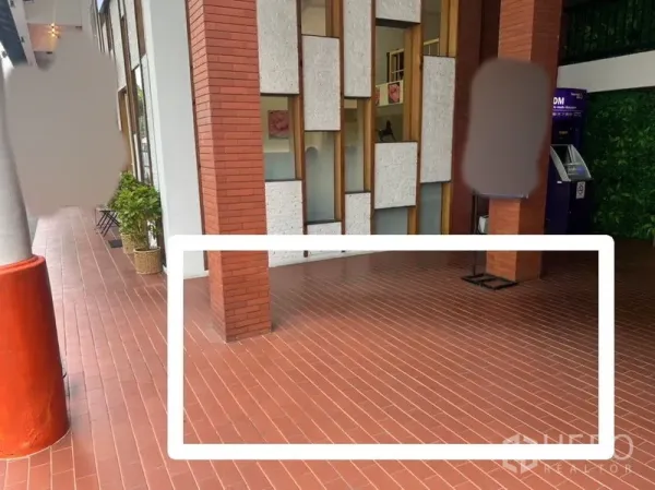 พื้นที่ขายปลีก ให้เช่า - พื้นที่คีออสขนาดเล็กบนระเบียงทางเดินกระเบื้องสีอิฐ ข้างเสาอิฐและตู้เอทีเอ็ม เหมาะสำหรับร้านบริการด่วน.