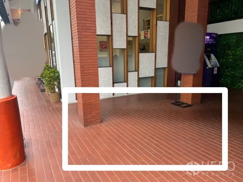 พื้นที่ขายปลีก ให้เช่า - พื้นที่คีออสขนาดเล็กบนระเบียงทางเดินกระเบื้องสีอิฐ ข้างเสาอิฐและตู้เอทีเอ็ม เหมาะสำหรับร้านบริการด่วน.