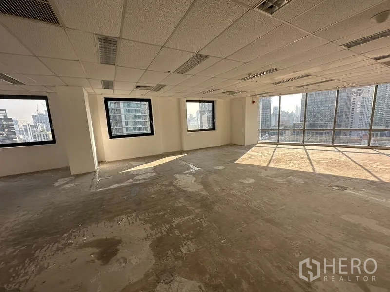 Office Space for rent - Bright open-plan office space with suspended ceiling, large corner windows and skyline views in Pathum Wan, Bangkok.