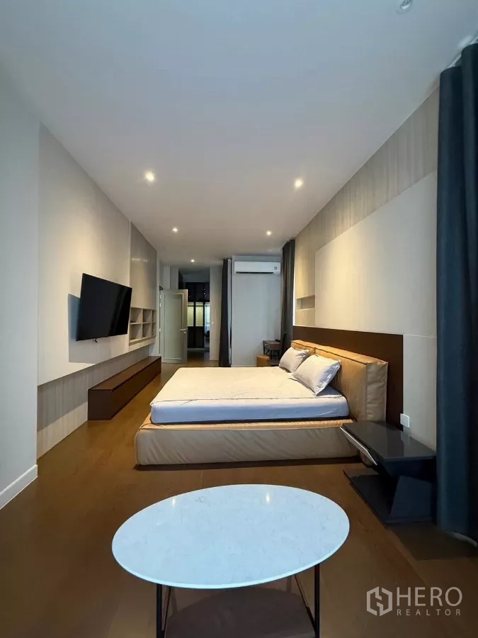 บ้าน ให้เช่าในSaphan Sung, Bangkok - ห้องนอนปูพื้นไม้ ทีวีติดผนัง และหน้าต่างบานใหญ่พร้อมผ้าม่าน