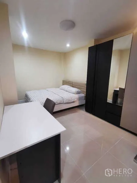 ทาวน์เฮาส์ ให้เช่าในChatuchak, Bangkok - ห้องนอนแขกพร้อมโต๊ะทำงาน ตู้เสื้อผ้าสีดำ และพื้นกระเบื้อง.