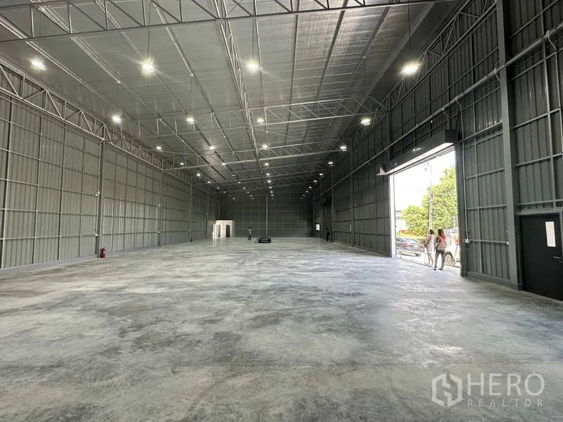 Warehouse for rent in Pak Kret, Nonthaburi - Clear-span warehouse interior showing insulated roof panels and loading entrance.