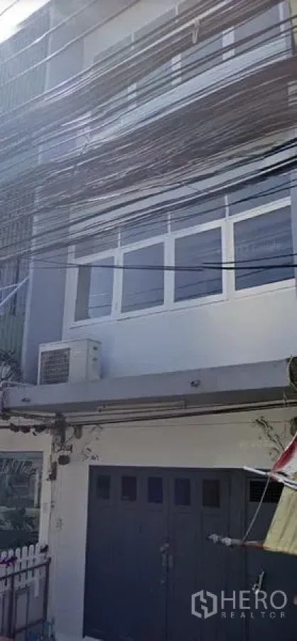 店屋 出租在Watthana, Bangkok - 三层店屋外立面，设宽大前门、窗户与外置空调机。