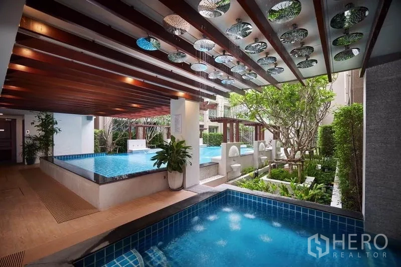 Condominium for sale in Huai Khwang, Bangkok - Condominium swimming pool with water features, covered deck and landscaped garden.