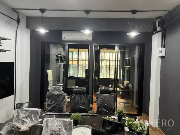 Home Office for rent in Pom Prap Sattru Phai, Bangkok - Boardroom view toward glass‑partitioned private offices with pendant lights and AC.