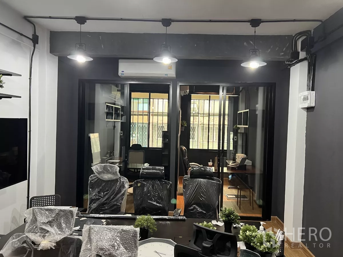 Home Office for rent in Pom Prap Sattru Phai, Bangkok - Boardroom view toward glass‑partitioned private offices with pendant lights and AC.