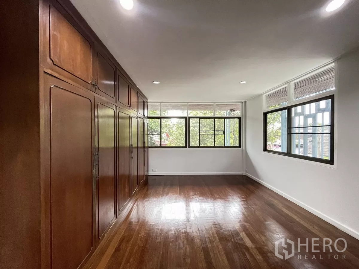 带办公室的家 出租在Din Daeng, Bangkok - 卧室设整面木质嵌入式衣柜与转角窗。