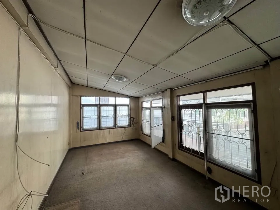 Detached House for rent or sale in Watthana, Bangkok - Empty room with windows and aged carpet ready for makeover.