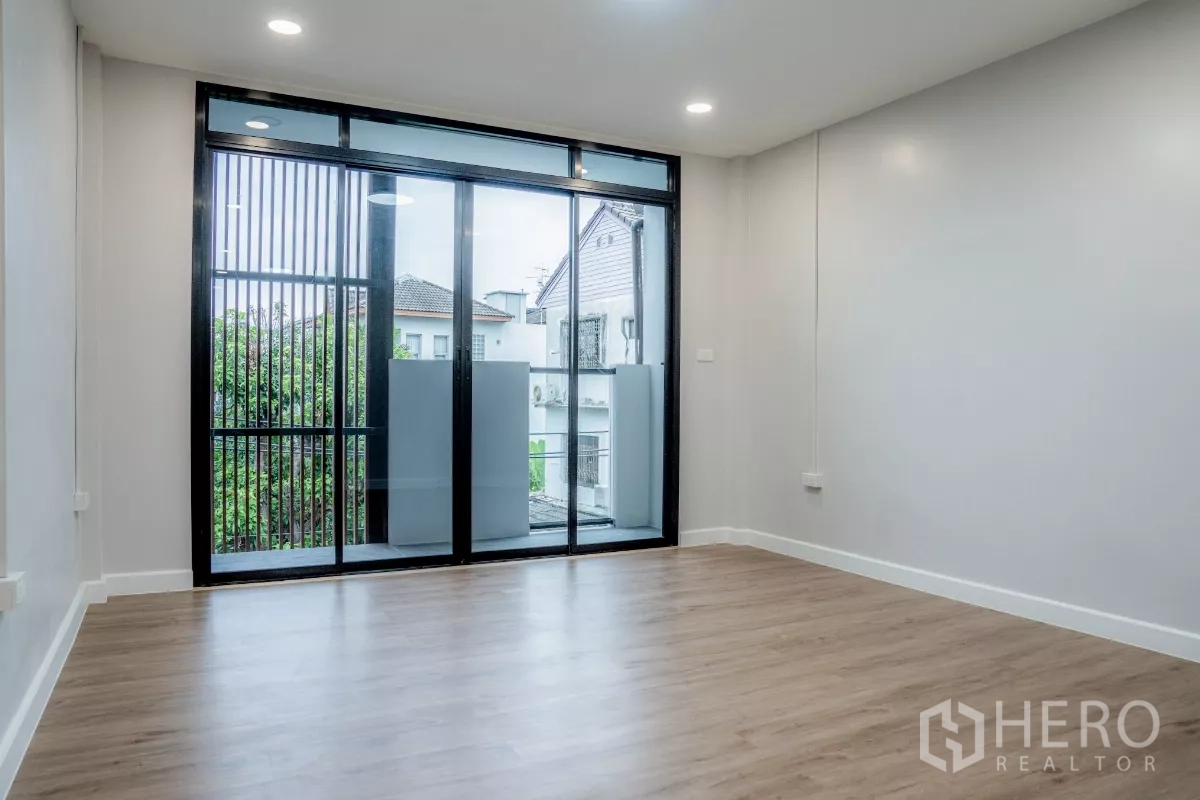 ทาวน์เฮาส์ ขายในWatthana, Bangkok - ห้องนอนกว้าง ประตูกระจกบานเลื่อนสู่ระเบียง พร้อมฉากระแนงบังสายตา