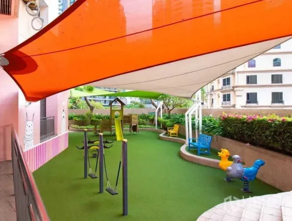 Condominium for rent in Khlong Toei, Bangkok - Colorful covered children’s playground with swings, slide and soft turf within the condo.
