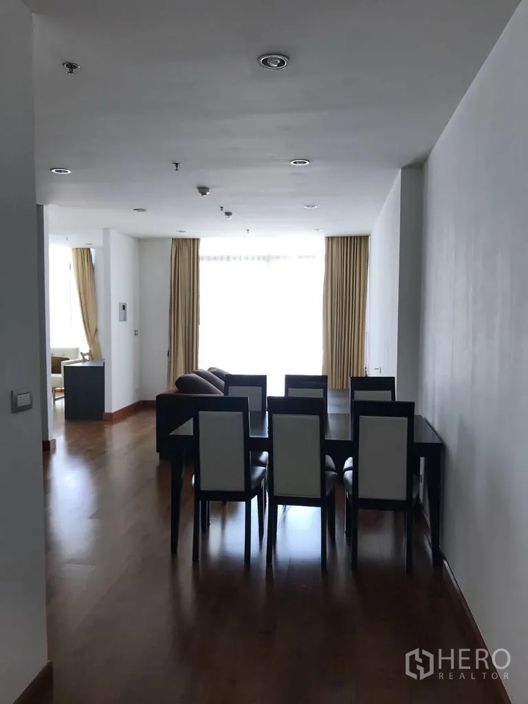 Condominium for rent in Watthana, Bangkok - Dining area facing bright living space with large windows and curtains