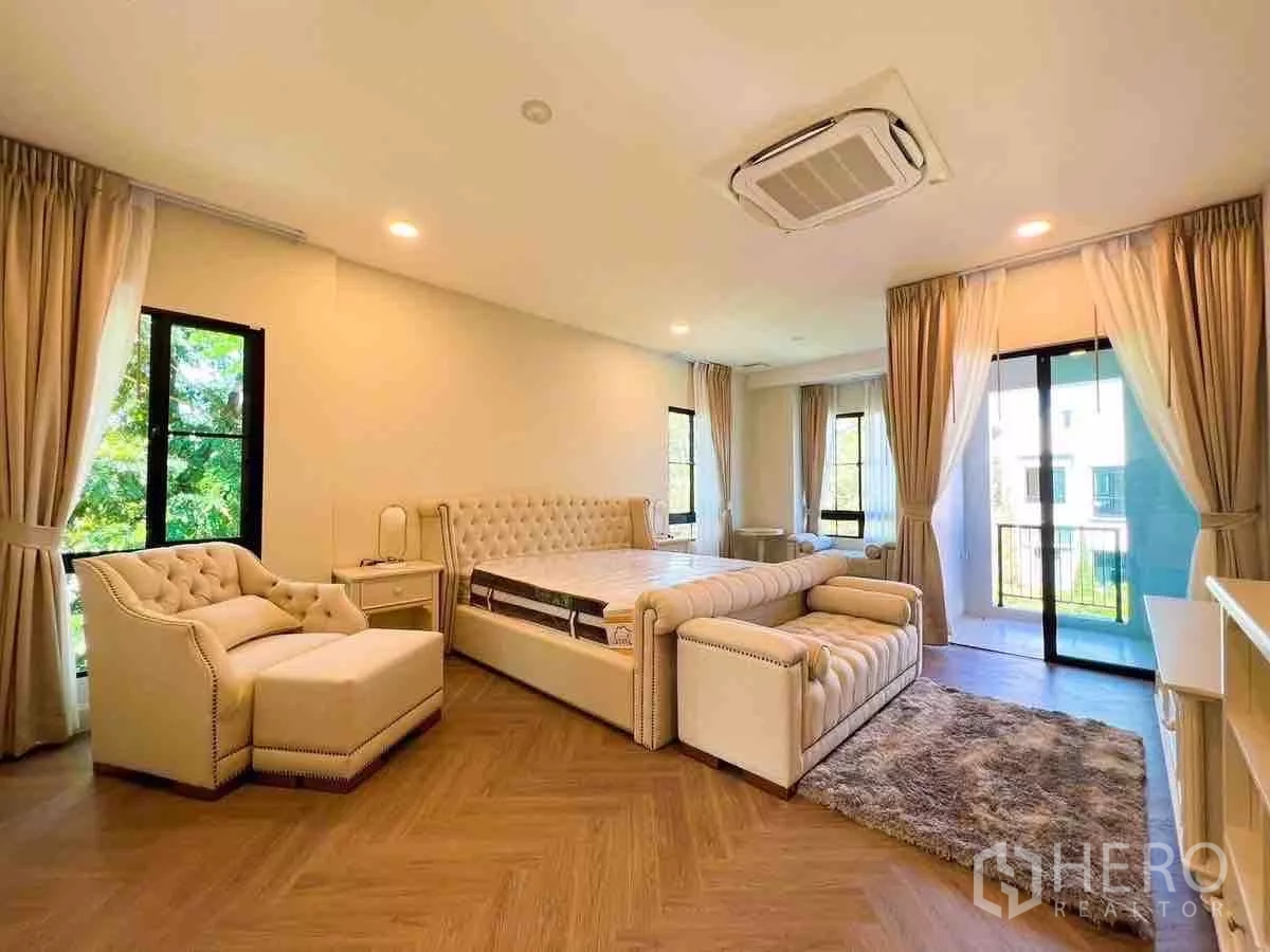 Detached House for rent or sale in Saphan Sung, Bangkok - Large master bedroom with chaise lounge, balcony access and wood floors