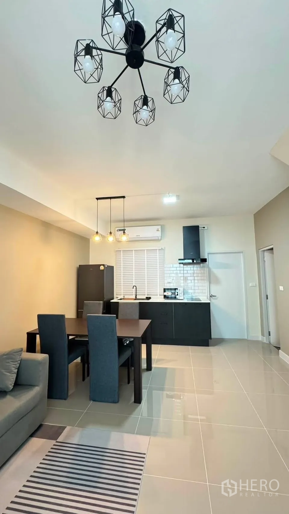 Townhouse for rent in Bang Phli, Samut Prakan - Open-plan dining and kitchen area with pendant lights and tiled flooring.