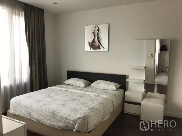 Condominium for rent in Bang Rak, Bangkok - Serene bedroom with large bed, full-height window, curtains and dressing corner with mirror.