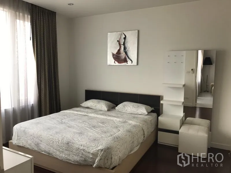 Condominium for rent in Bang Rak, Bangkok - Serene bedroom with large bed, full-height window, curtains and dressing corner with mirror.