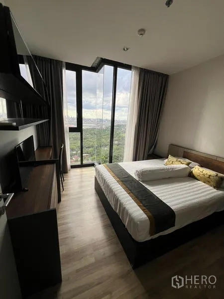 公寓 出租在Chatuchak, Bangkok - 明亮卧室，双人床、床头柜与通高落地窗。