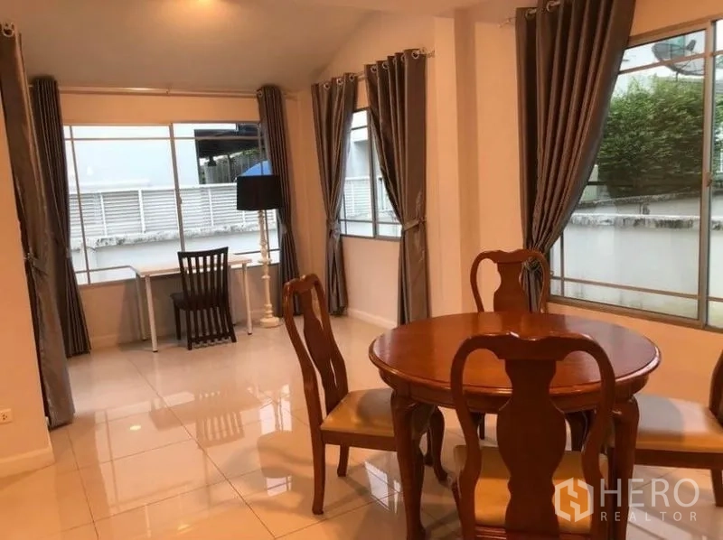 Detached House for rent in Prawet, Bangkok - Corner dining space with multiple windows and a small work desk.