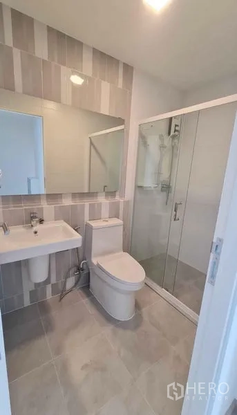 ทาวน์เฮาส์ ให้เช่าในPrawet, Bangkok - ห้องน้ำที่สองกรุผนังลายเส้น กระจกเงาบานใหญ่ และตู้ shower.