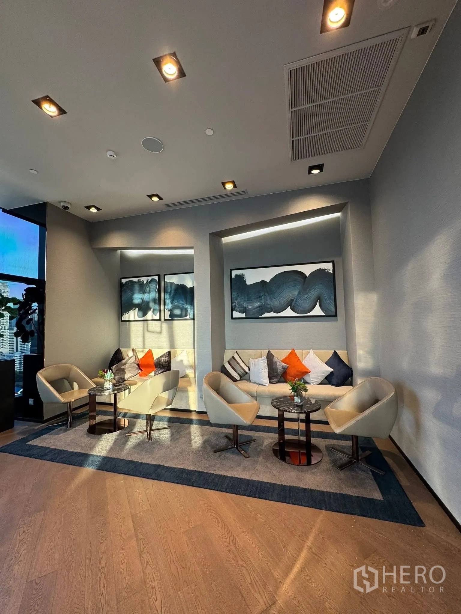 คอนโด for rent in Khlong Toei, Bangkok - เลานจ์พักผ่อนสว่างไสว มีเก้าอี้โมเดิร์น โซฟา และงานศิลป์ผนัง