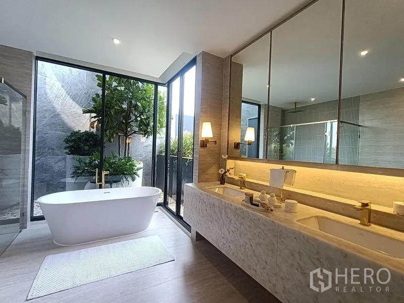 บ้าน ขาย - ห้องน้ำสปาพร้อมเคาน์เตอร์คู่ อ่างอาบน้ำเดี่ยว และหน้าต่างสูงจรดเพดานมองเห็นสวน