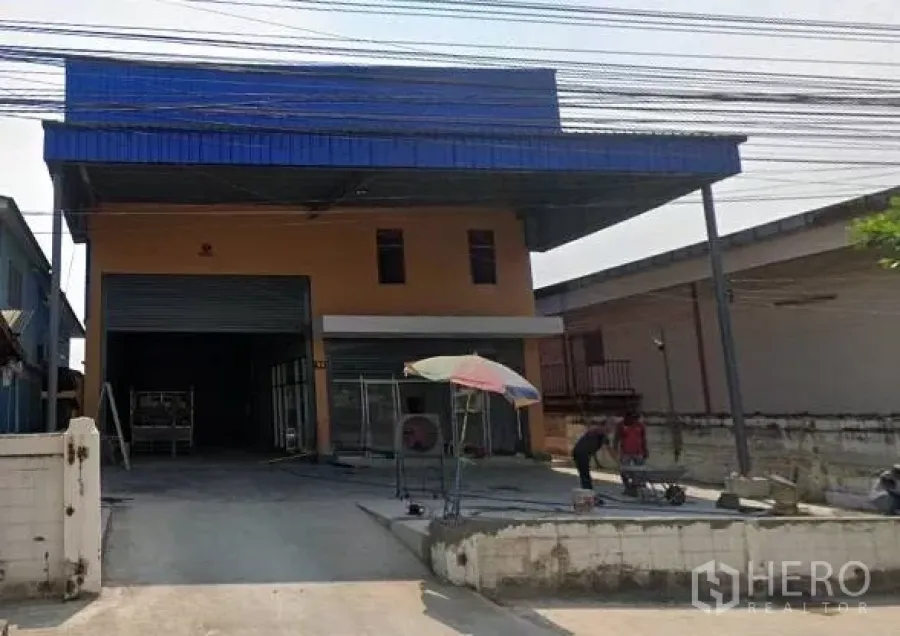 Warehouse for rent in Bang Khun Thian, Bangkok - Front view of a newly built warehouse with a large roller shutter and covered loading bay.
