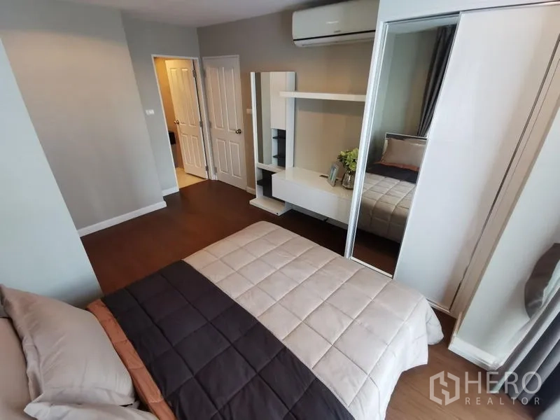 Condominium for rent or sale in Huai Khwang, Bangkok - Bedroom with mirrored wardrobe, vanity and door to ensuite.