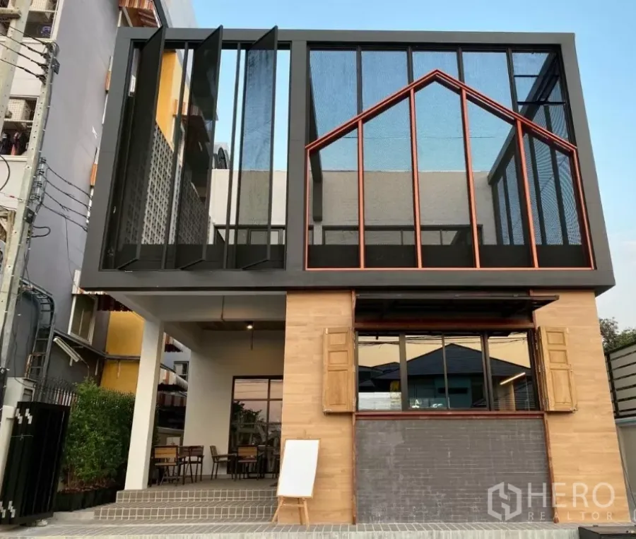 Detached House for sale in Mueang Nakhon Pathom, Nakhon Pathom - Modern two-storey detached house facade with large glass panels, metal frames and a street-side patio.