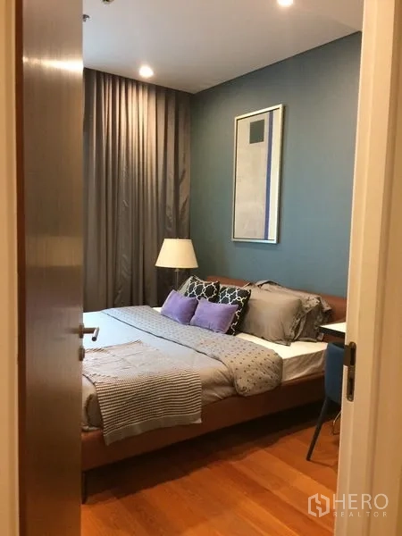 คอนโด ให้เช่าในKhlong Toei, Bangkok - ห้องนอนผนังสีฟ้า เตียงบุนวม หมอนหลายใบ และผ้าม่านทึบ