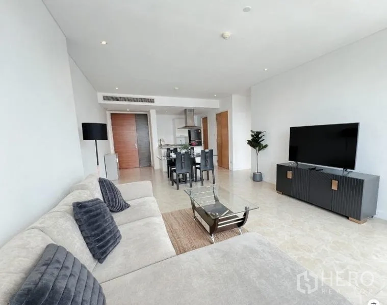 คอนโด ขายในWatthana, Bangkok - ห้องนั่งเล่นสว่าง โซฟาตัวแอล ตู้ทีวี และมุมทานอาหารในคอนโดโมเดิร์น