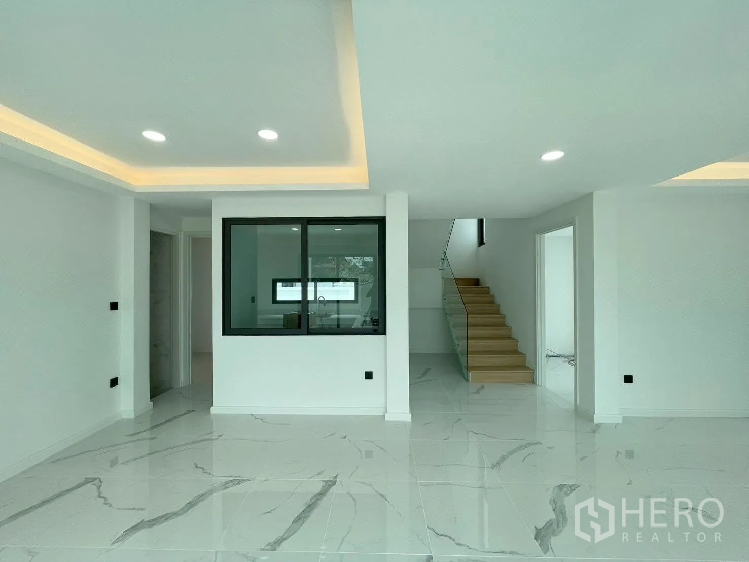 Detached House for sale in Chatuchak, Bangkok - Ground floor open-plan living area with marble-look floors and a view toward the kitchen.