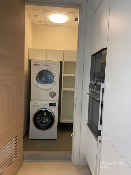 คอนโด ให้เช่าในPathum Wan, Bangkok - ห้องซักรีด เครื่องซักผ้า–อบผ้าแบบซ้อน และชั้นเก็บของ พร้อมเตาอบบิวท์อิน