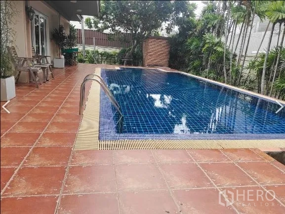 Detached House for rent in Huai Khwang, Bangkok - Private swimming pool with blue tiles beside terrace and garden
